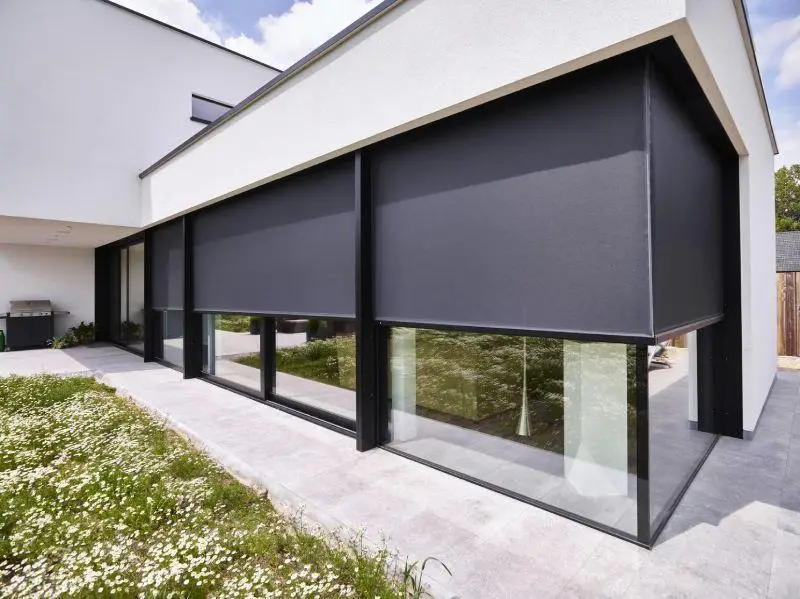 Ramen deuren zonwering: moderne woning met grote raampartijen en buitenscreens