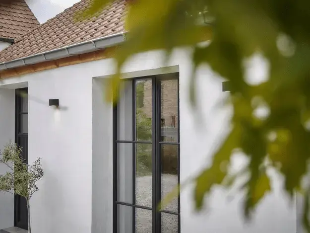 Donkere aluminium ramen en deuren in een witte gevel