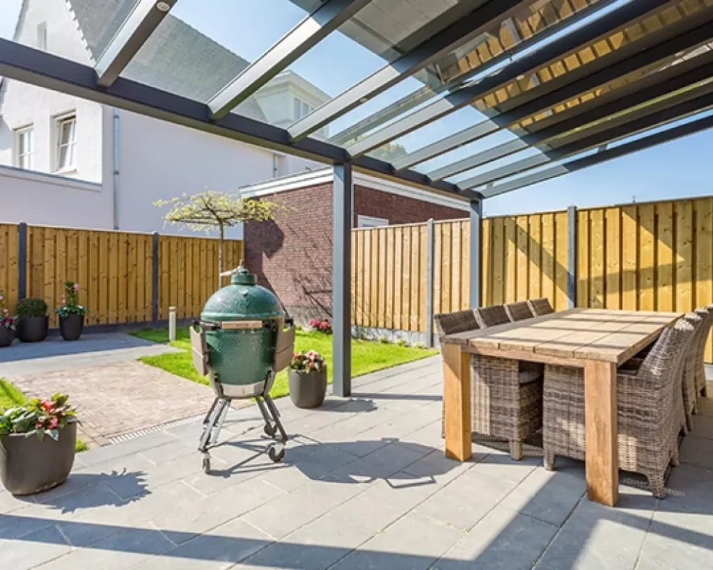 Overdekte patio Tielt met veranda zonwering - Houten eettafel met rieten stoelen onder windvaste screens