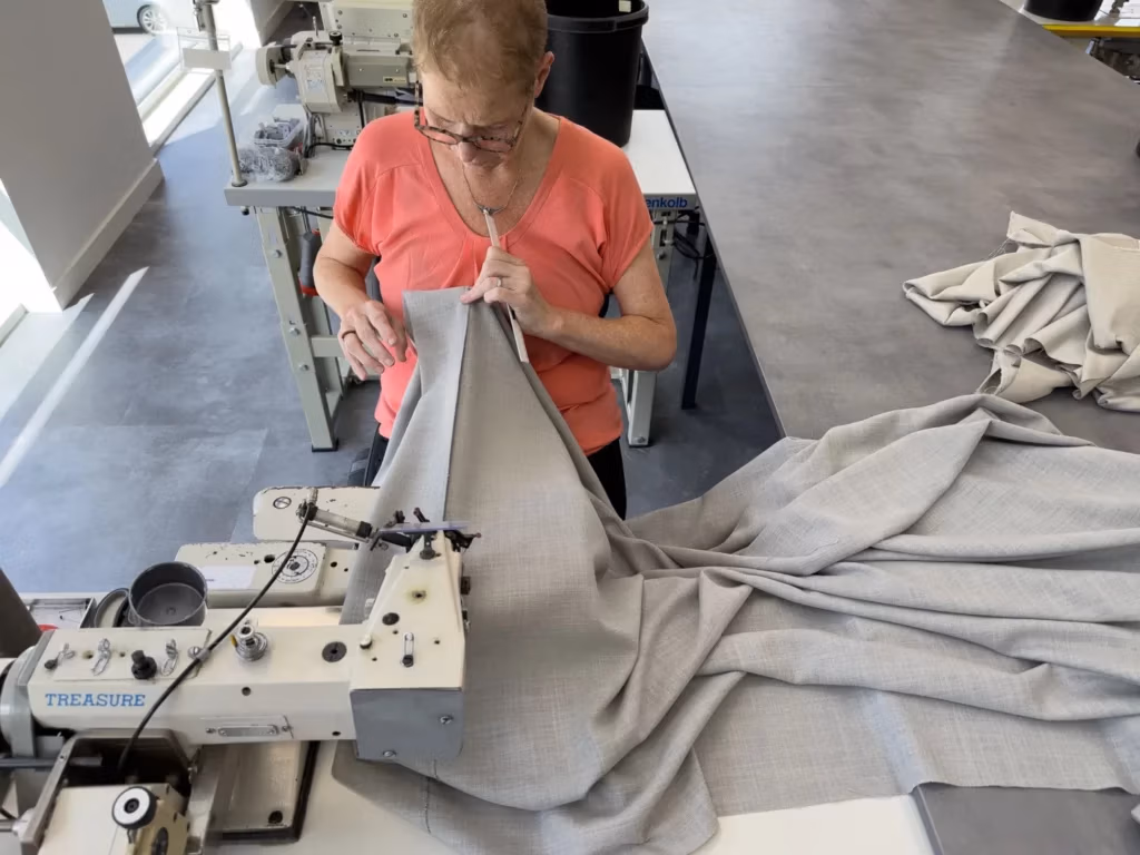 Gordijnstof op maat wordt genaaid aan de naaimachine in het atelier van RDT Concept in Menen