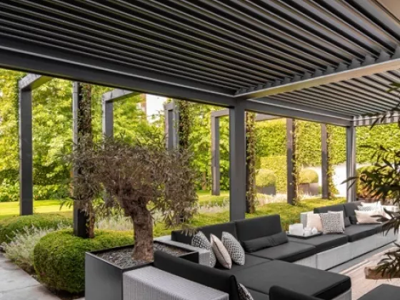 Buitenbeleving met een Verano lamellendak boven een terras met loungeset