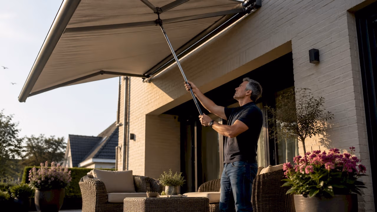 Man zet het zonnescherm uit op het terras