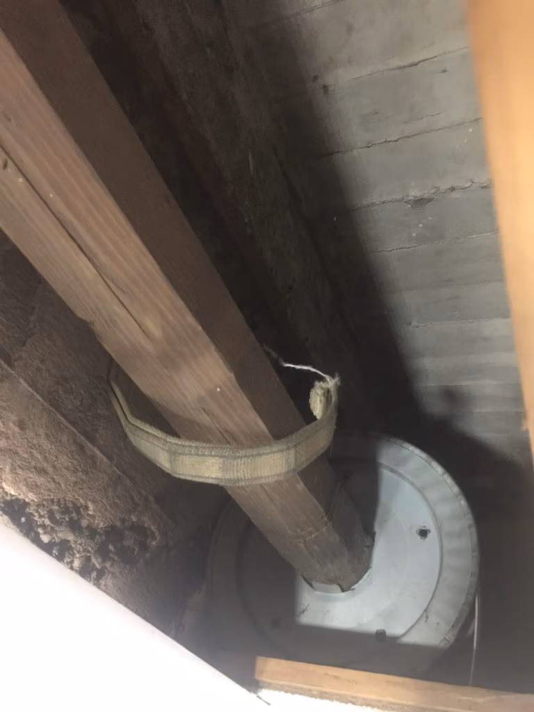 Oude houten rolluikas en lint in een geopende rolluikkast
