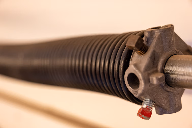 Close-up van een onderdeel van het veermechanisme van een garagepoort – garagepoort herstellen in Kuurne